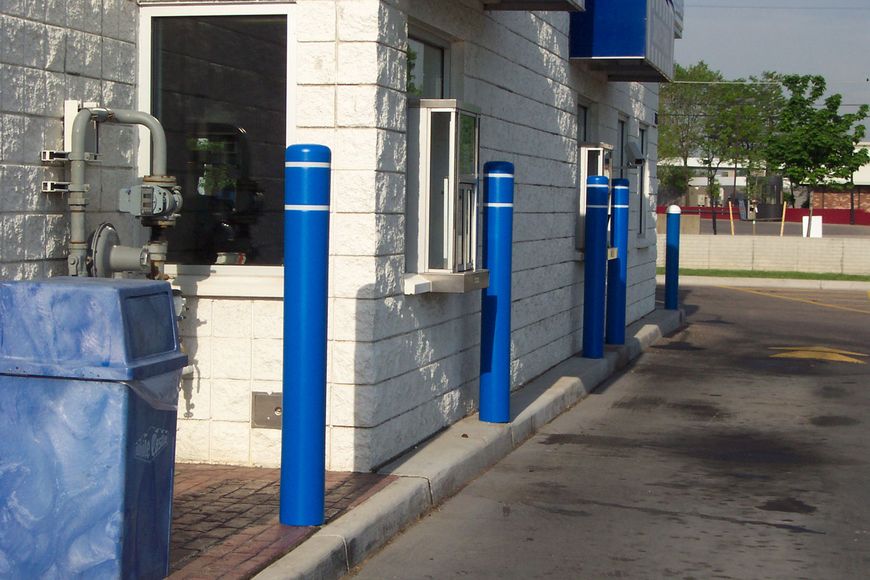 Blue bollards circled with white reflective tape protect a fast-food drive through