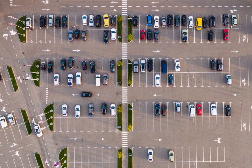 Aerial view of a parking lot with perpendicular stalls and two-way lanes