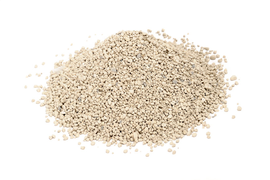 A pile of light-colored bentonite clay cat litter sits on a plain white background